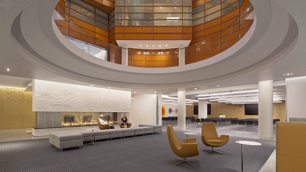A large room with a few people sitting at a table.